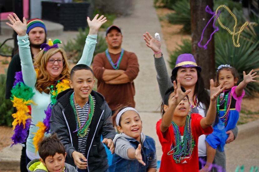The crowd grabs for beads during the Oak Cliff Mardi Gras Parade in Dallas Feb. 15, 2015.