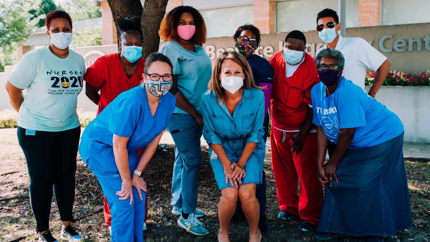 A group of nurses wearing masks pose together.