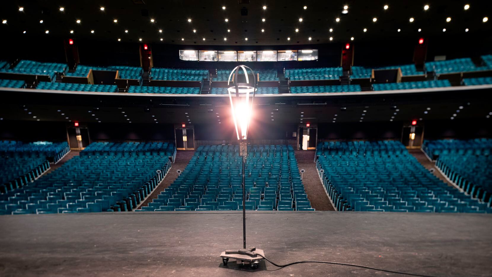 A ghost light illuminates a darkened stage at the empty Music Hall at Fair Park in Dallas,...