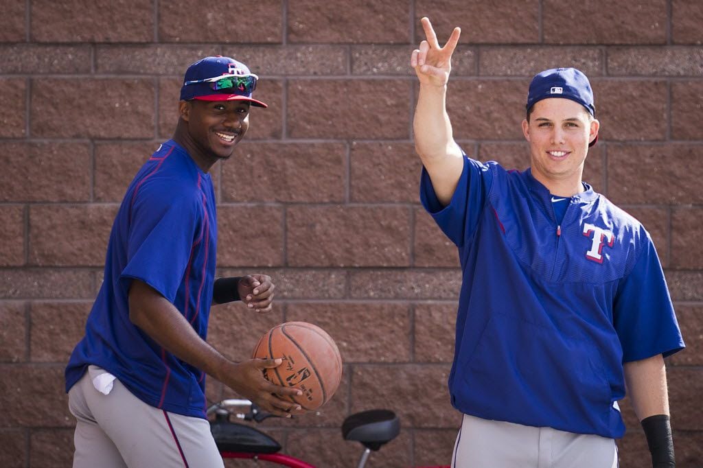 Texas Rangers infielder Drew Robinson (right) and outfielder Lewis Brinson play basketball...
