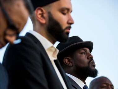 Dr. Michael W. Waters (right) and Imam Omar Suleiman (center) listen to a speaker during the...