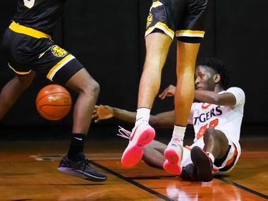 Lancaster's Jordan Williams (22) controls a loose ball during a boys high school basketball...