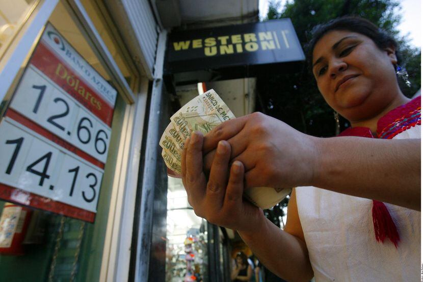 Una mujer retira dinero enviado desde Estados Unidos en un establecimiento en la Ciudad de...
