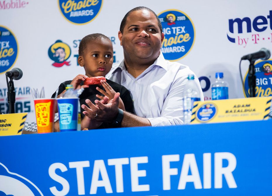 Dallas Mayor Eric Johnson and his son, William, try the Big Red Chicken Bread during the Big...
