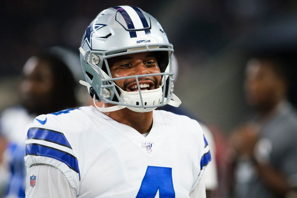 Dallas Cowboys quarterback Dak Prescott laughs as he warms up before an NFL preseason...