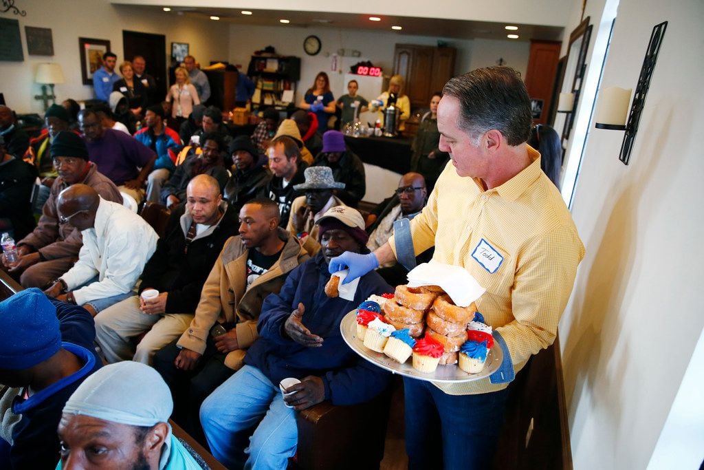 Todd Garner hands out pastries before worship service at SoupMobile Church for the homeless in Dallas on Feb. 4, 2018. 