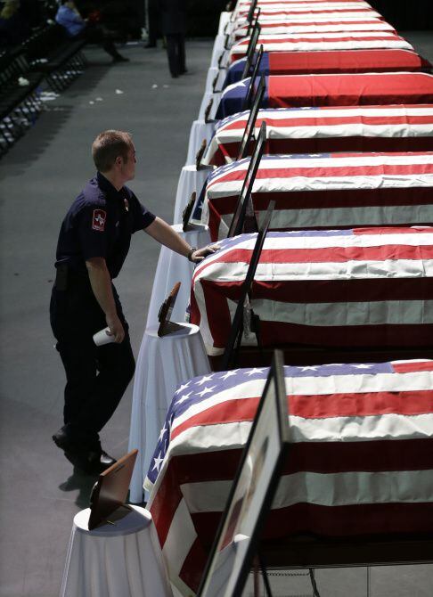Paramedic Bryce Reed leaned on the casket of firefighter Cyrus Reed after a service where he...