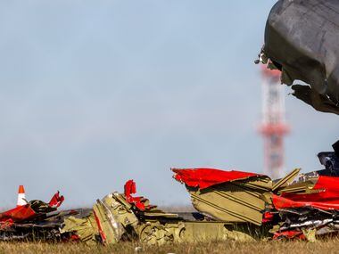 Debris lays scattered around a damaged plane at the Dallas Executive Airport on Sunday, Nov....