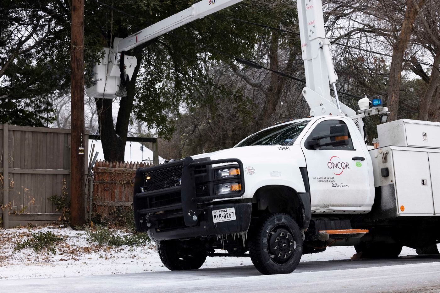 An Oncor technician works on a power line close to the intersection of W Illinois Ave and S...