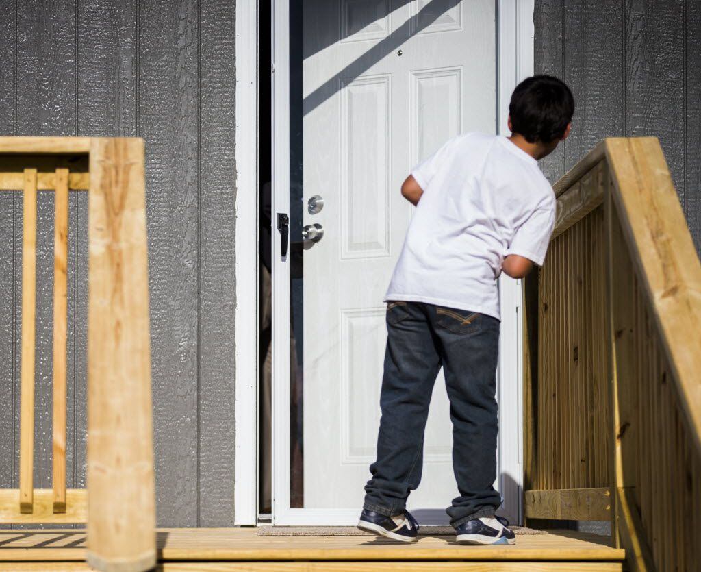 Michael Santillano, 7, tries to take a peak inside his family's new home before it was...