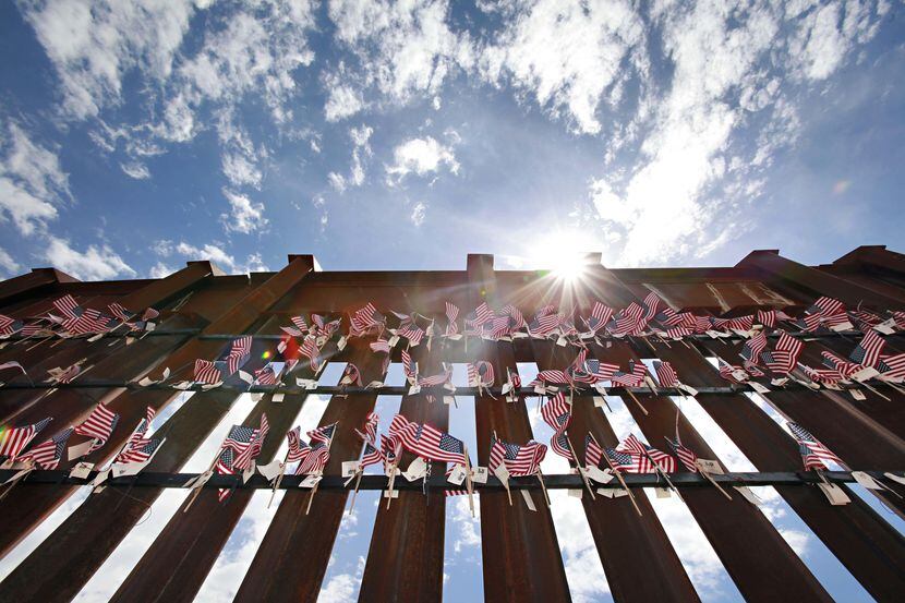 Unas banderitas cuelgan de la barda internacional en Hereford, Arizona. (AP/MATT YORK)
