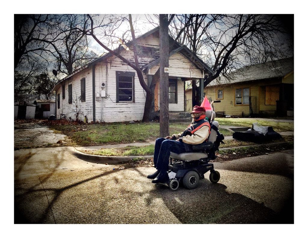 A man on a motorized scooter passes through a South Dallas neighborhood.