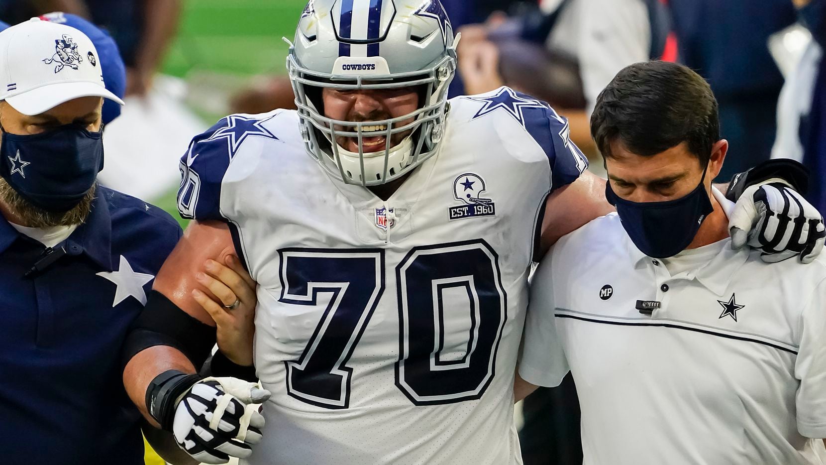 Cowboys right tackle Zack Martin is helped off the field after being injured during the first quarter of a game against Washington at AT&T Stadium on Thursday, Nov. 26, 2020, in Arlington.