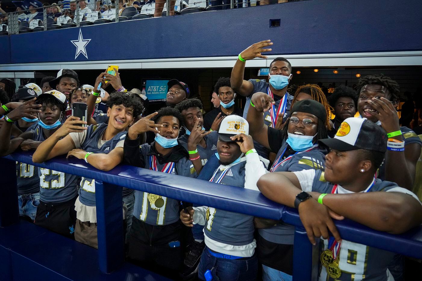 Members of the South Oak Cliff state championship football team cheer as the Dallas Cowboys warm up before the first half of an NFL football game against the Washington Football Team at AT&T Stadium on Sunday, Dec. 26, 2021, in Arlington.