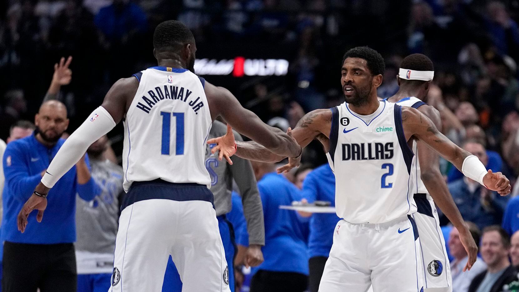 Dallas Mavericks' Tim Hardaway Jr. (11) and Kyrie Irving (2) celebrate after a time out was...