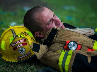 University Park firefighter Scott Rattan rests after battling flames at Goff's Hamburgers on...