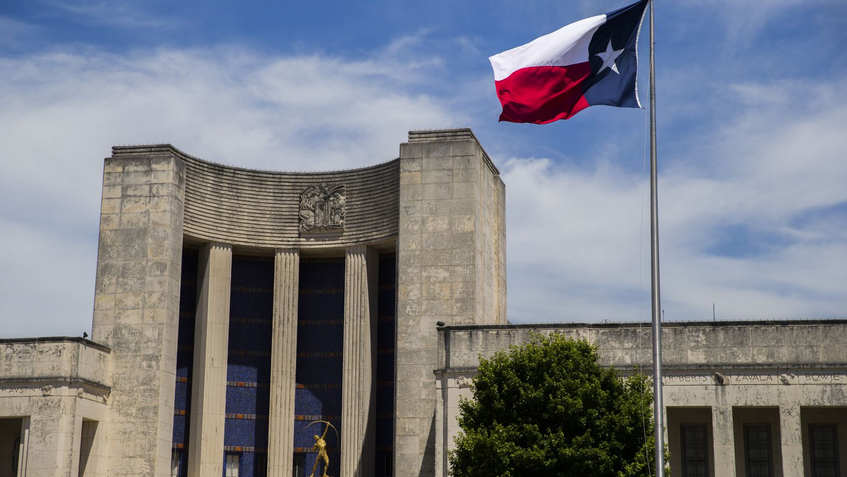 A Texas flag flies over the Hall of State at Fair Park on Tuesday, June 18, 2019.