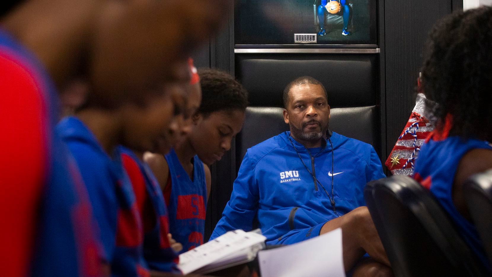 Travis Mays (center), head coach of SMU women's basketball, watches his team as they take...