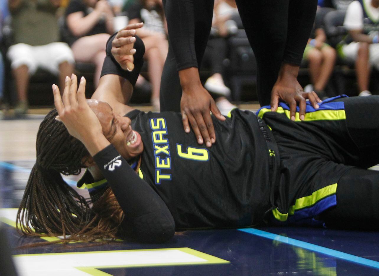 Dallas Wings forward Kayla Thornton (6) winces after colliding with an LA Sparks player on a...