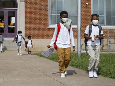 Jerrell Brown, 9 (left), walks with Jayce Williams, 7, after a day of classes at Paul L. Dunbar Learning Center on Wednesday, Sept. 8, 2021, in Dallas. (Elias Valverde II/The Dallas Morning News)