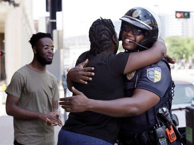 In this June 30, 2017, photo, Shetamia Taylor hugs Dallas Area Rapid Transit Police Officer...