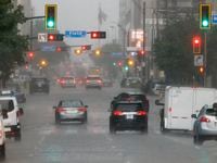Cars drive along Commerce Street during a thunderstorm in downtown Dallas, Tuesday, Aug. 9,...