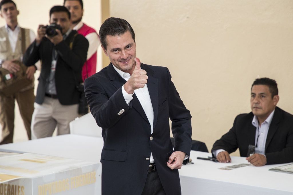 Mexican President Enrique PeÃ±a Nieto gives a thumb up after voting in polling station at...