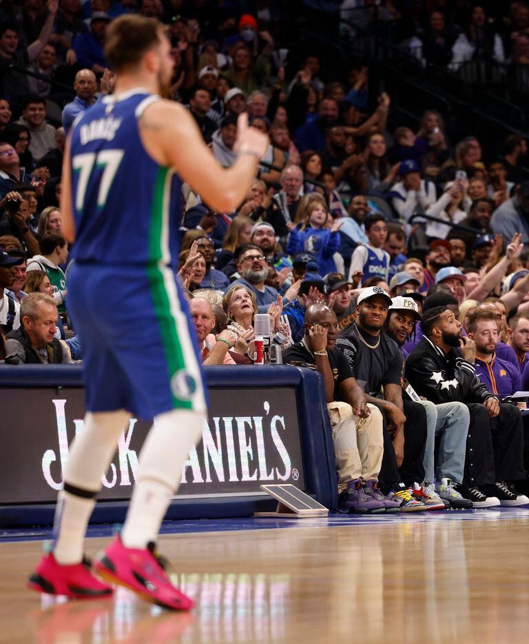 Dallas Mavericks guard Luka Doncic (77) celebrates a basket as Dallas Cowboys players Micah...
