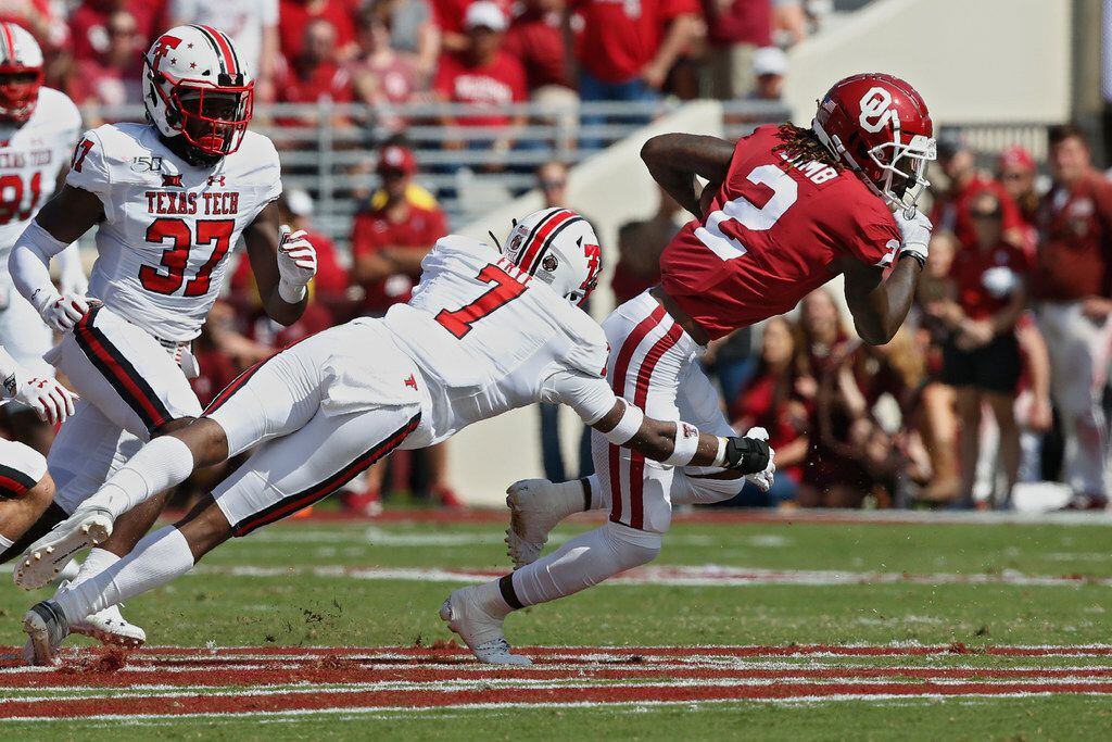 Oklahoma wide receiver CeeDee Lamb (2) avoids a tackle by Texas Tech defensive back Adrian...