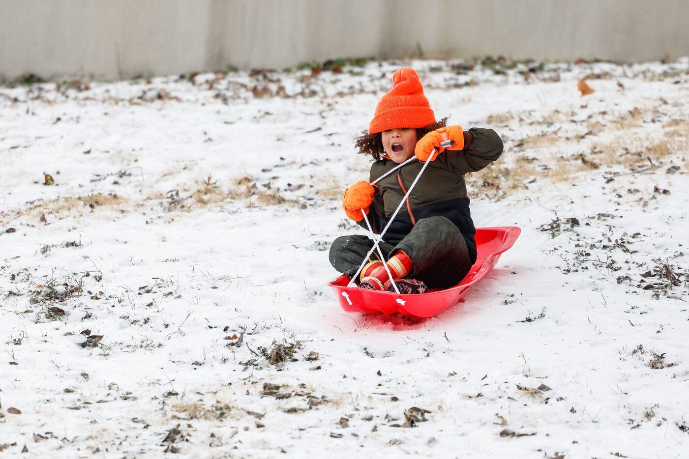 Miles Jarret, 4, slides down the hillside covered by sleet near at White Rock Lake in Dallas...
