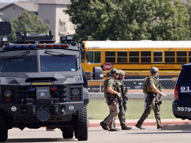 Tactical officers clear the scene following a shooting inside Mansfield Timberview High School in Arlington, Texas, Wednesday, October 6, 2021. Four people were injured in the shooting and the suspect turned himself into the Arlington police.