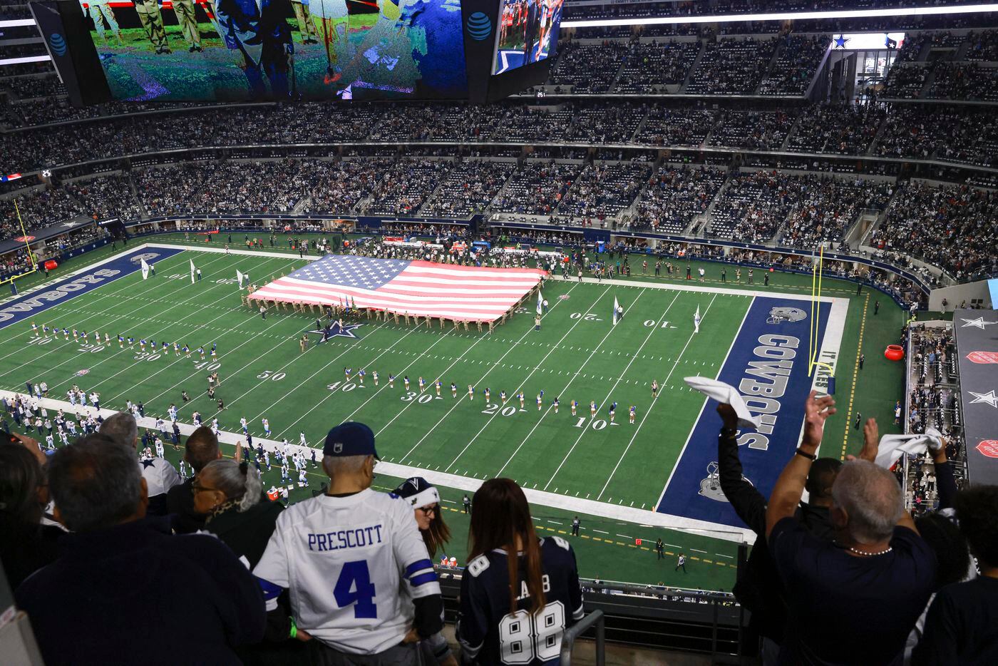 Dallas Cowboys fans stand in the stands as the national anthem is plays before an NFL game...