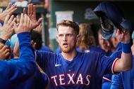 Texas Rangers catcher Sam Huff celebrates with teammates as he returns to the dugout after...