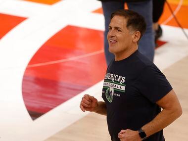 Dallas Mavericks owner Mark Cuban smiles as he makes his way across the court after game 6...