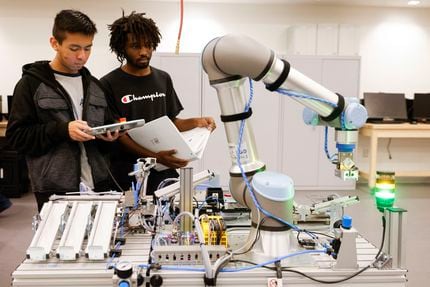 Brandon Mendoza (left) and Roman Willis inspect a robot at Career Institute North on...