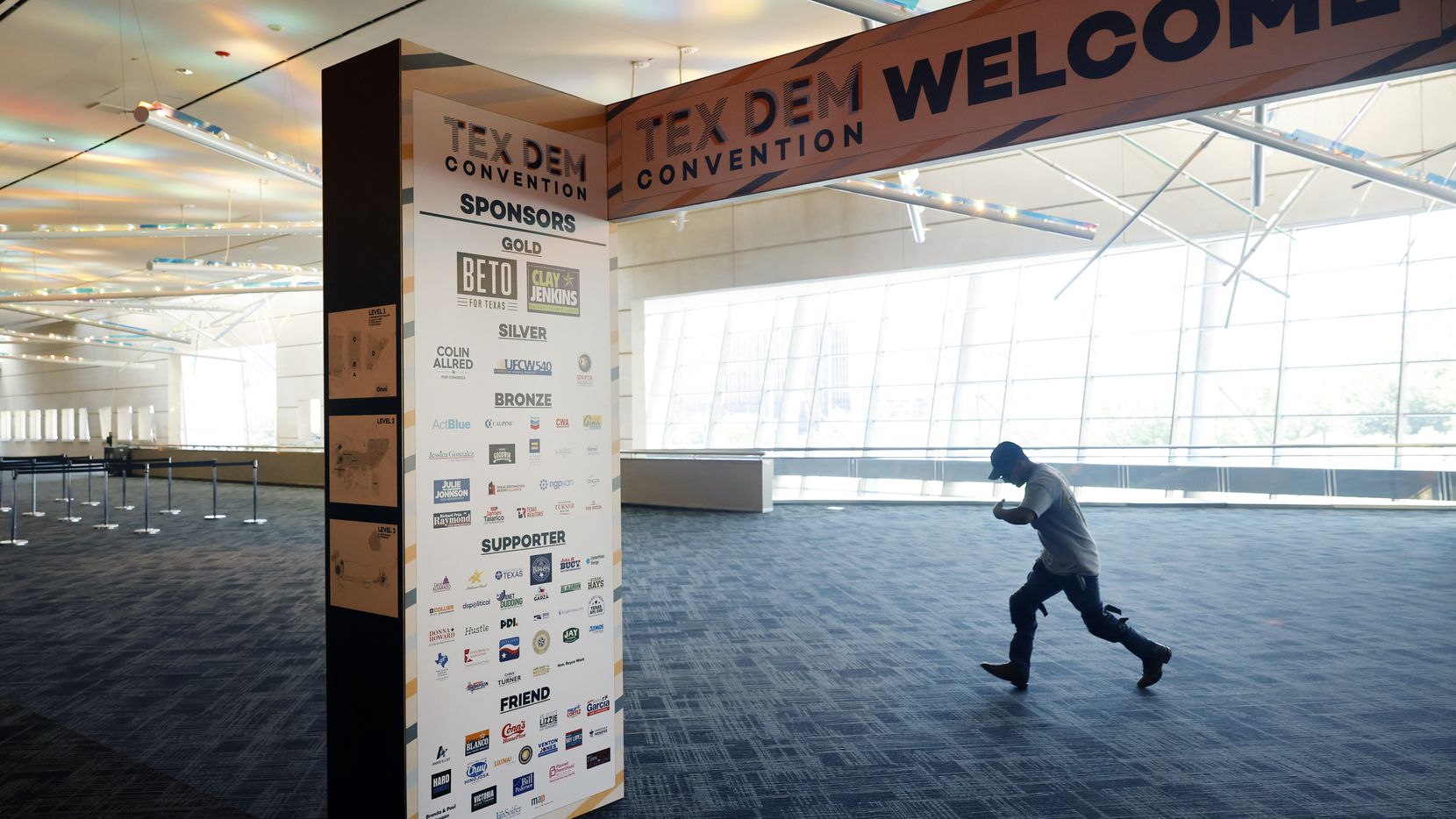 A crewman hustles to the exhibit hall as people set up ahead of the 2022 Texas Democratic...