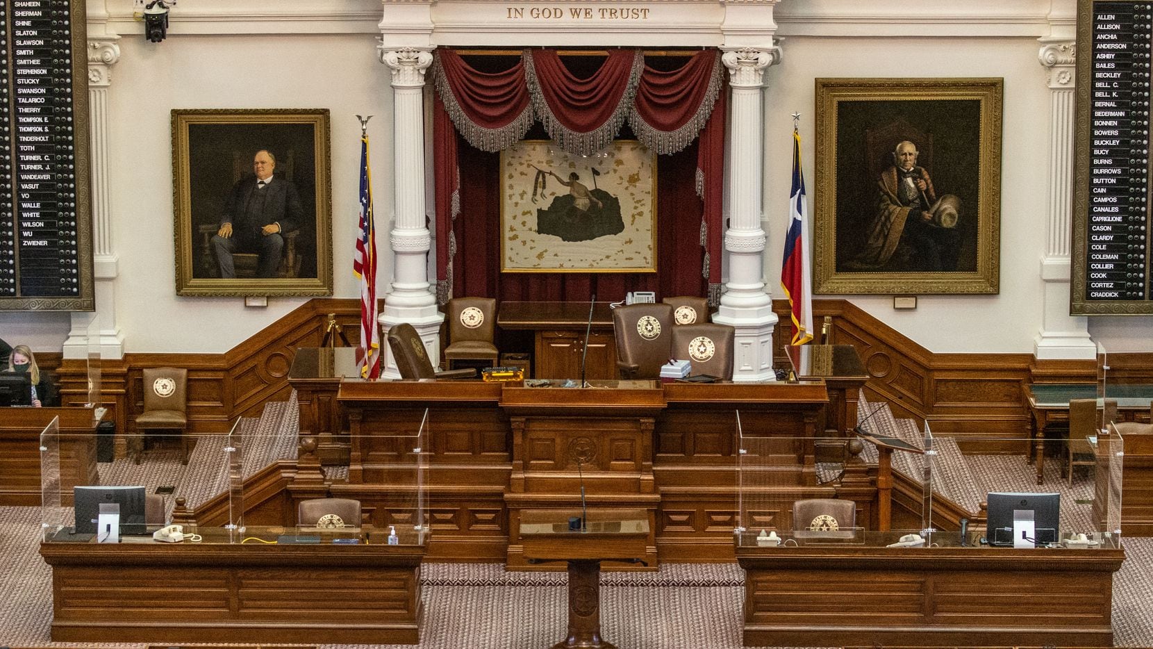Acrylic glass barriers line certain desk areas in the House Chamber at the Texas State...