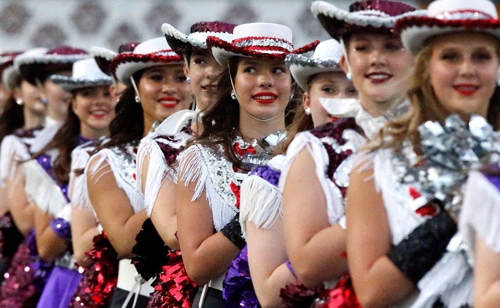 Reese McDonald (center), 14, with the Clark High School Cougarettes stands at attention on...