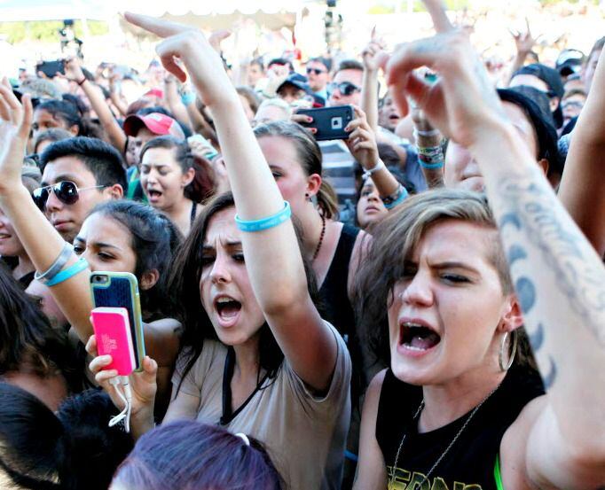 Fans react with fist pumps during the Vans Warped Tour 2016.