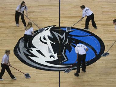 The Mavs logo at half court gets some TLC during a time out during the Orlando Magic vs. the Dallas Mavericks NBA basketball game at the American Airlines Center in Dallas on Tuesday, January 9, 2018.