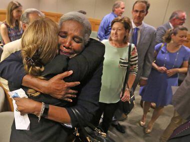 Former Judge Suzanne Wooten (left, back to camera) gets a hug from Cynthia Fitzgerald Lacy...