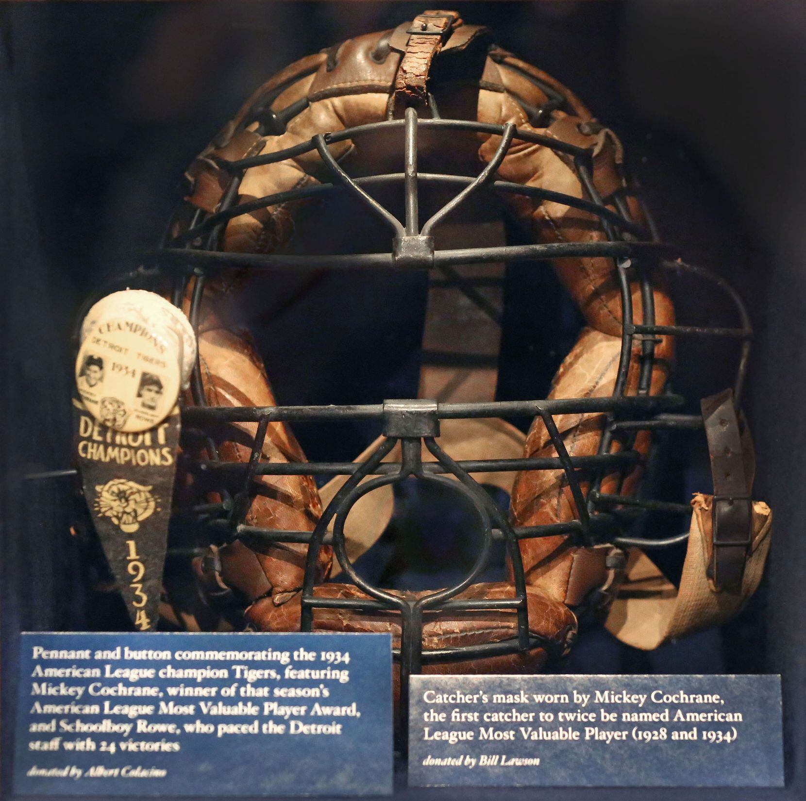 A catchers mask, complete with a hole through which the catcher could spit tobacco, is...
