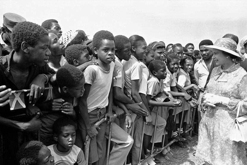 Jamaican school children greet Queen Elizabeth II at the National Heroes Monument in...