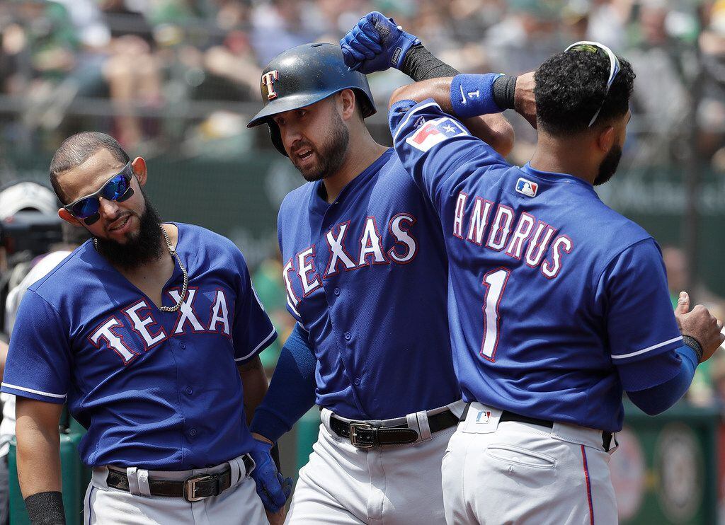 Texas Rangers' Joey Gallo, center, is congratulated by Rougned Odor, left, and Elvis Andrus...