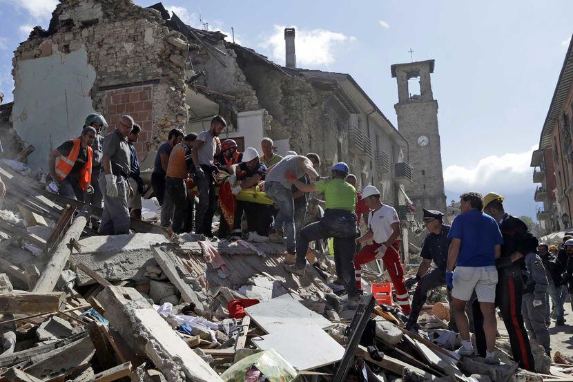 Rescatistas cargan una camilla mientras buscan sobrevivientes de un potente sismo que...