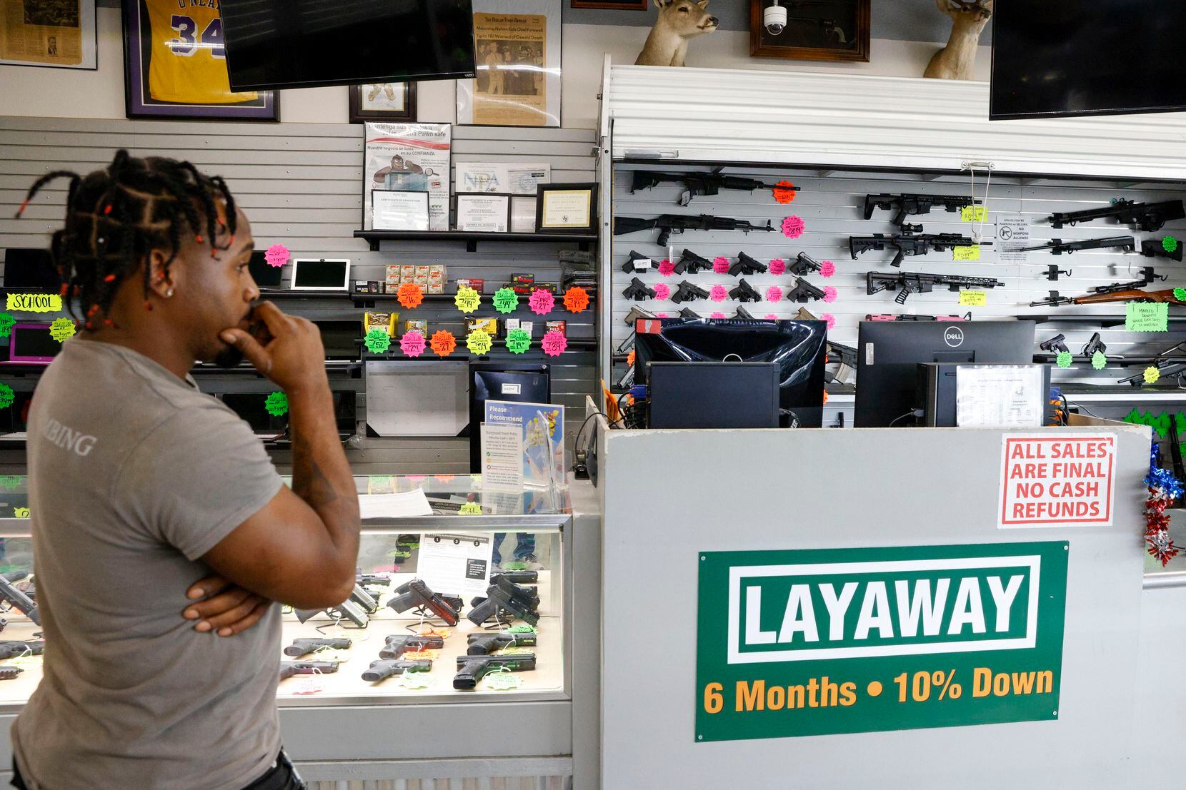 Brian Benford, 31, waits for an employee to retrieve a gun from the back while he shops at...