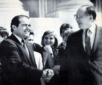 New Chief Justice William Rehnquist (right) shakes hands with the newest Associate Justice...