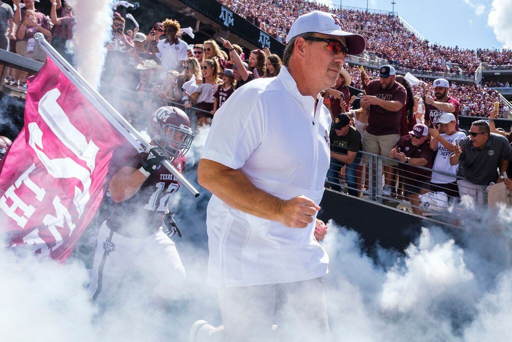 Texas A&M head coach Jimbo Fisher leads his team as they take the field to face Auburn in an...