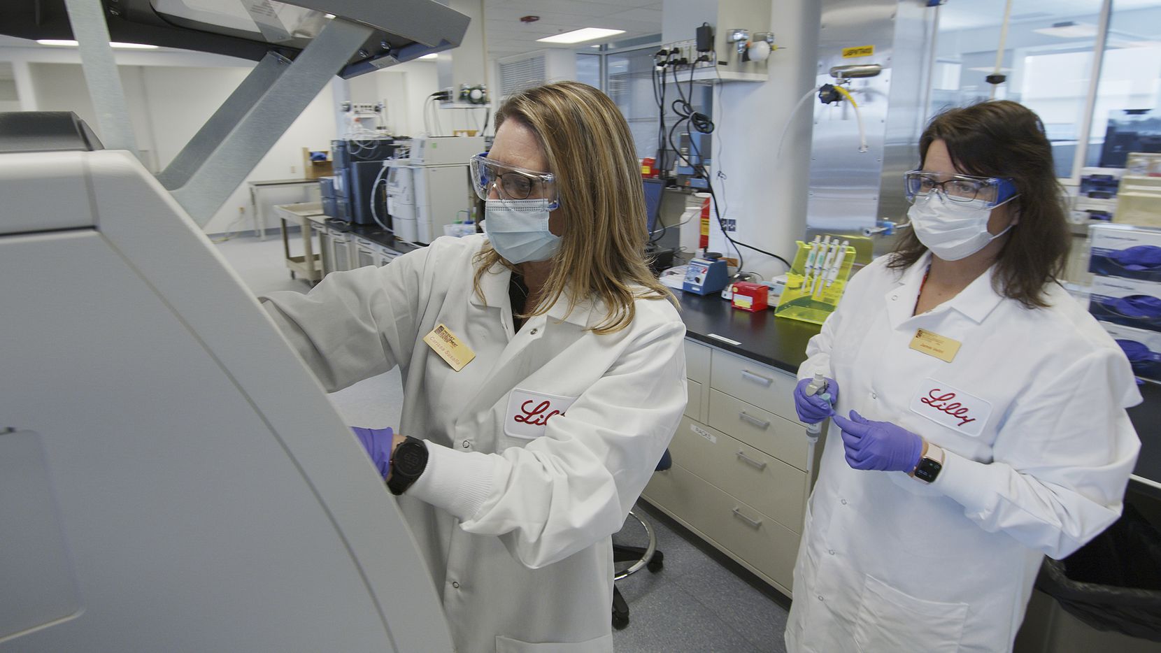 In this May 2020 photo provided by Eli Lilly, researchers prepare cells to produce possible...