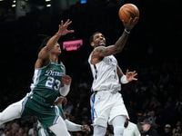 Brooklyn Nets' Kyrie Irving, right, drives past Detroit Pistons' Jaden Ivey during the first...